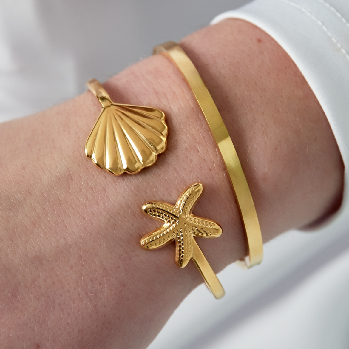 Bangle armband met schelp en zeester | Goudkleurig